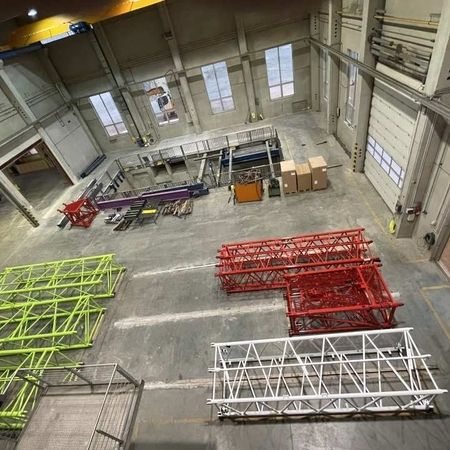 Verschiedenfarbig lackierte Metallrahmen liegen in der Halle auf dem Boden