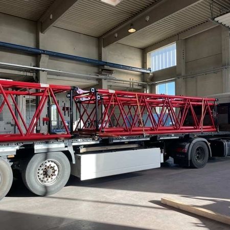 Mehrere rot lackierte Metallrahmen werden von einem LKW abtransportiert
