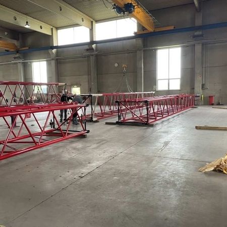 Mehrere rot lackierte Metallrahmen liegen in der Halle zum Trocknen aus